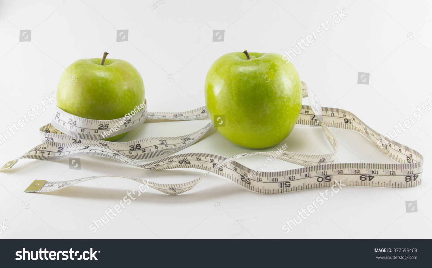 Green apple with Measuring tape on white background in concept of healthy and diet #377599468
