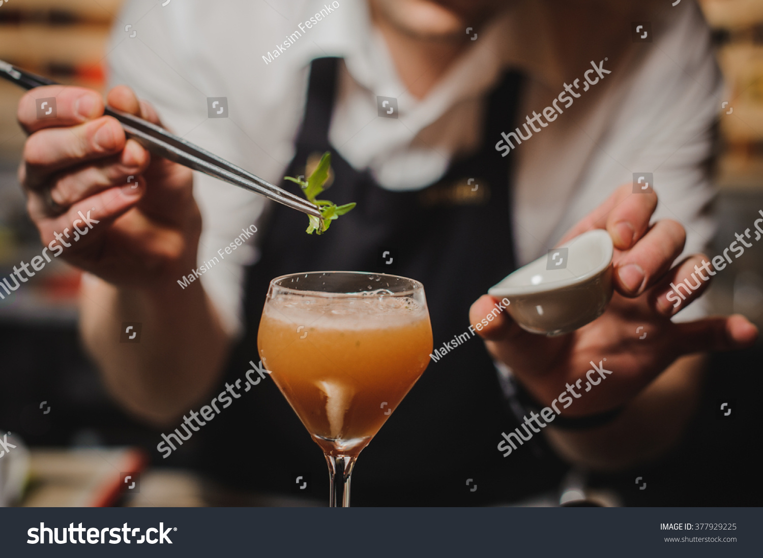 Barman is decorating cocktail with rocket no face #377929225