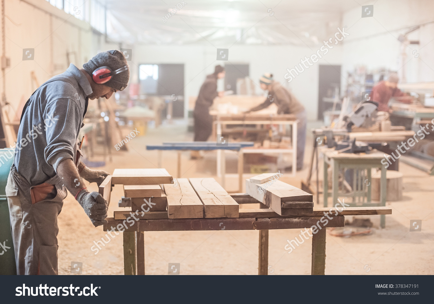 Man doing woodwork in carpentry. Carpenter work on wood plank in workshop #378347191