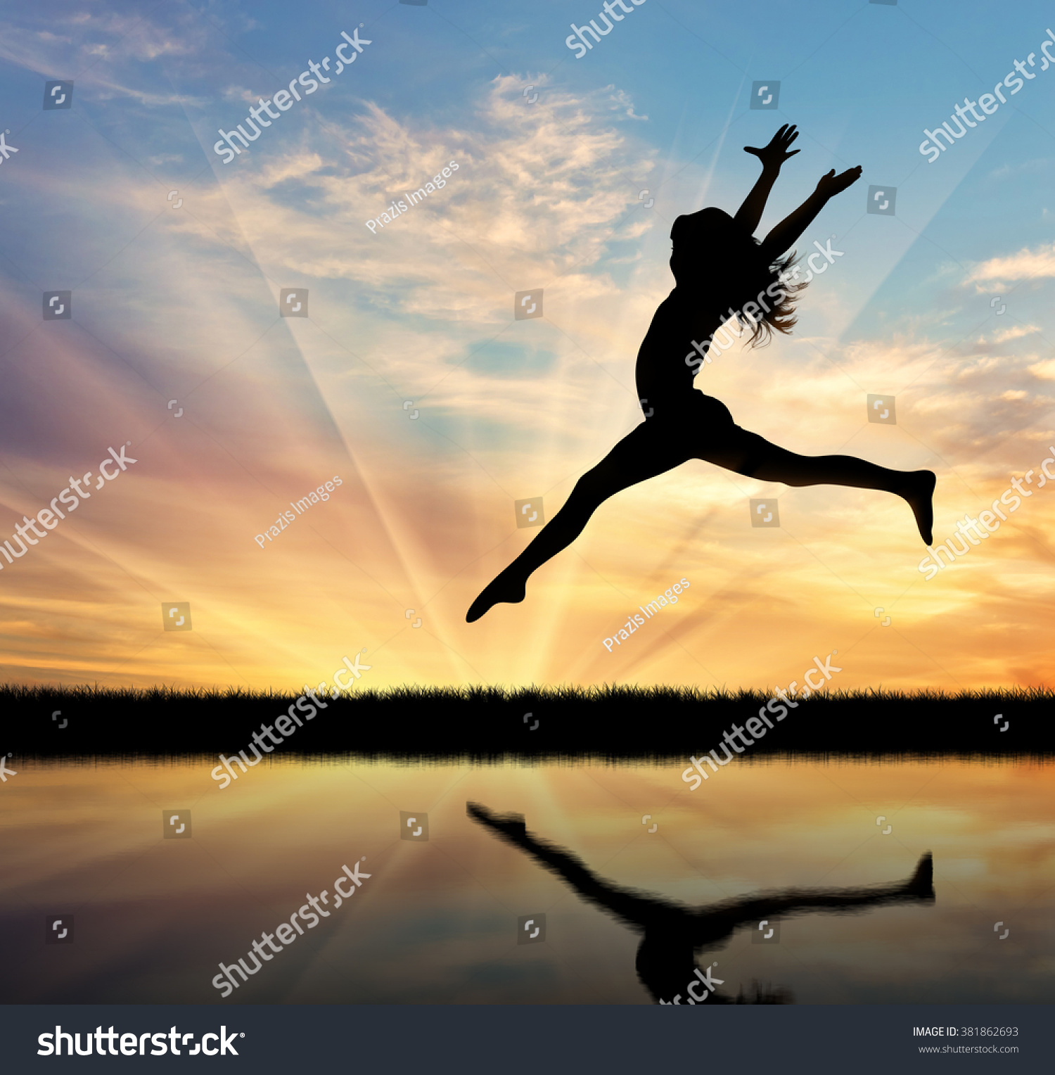 Concept of happiness and freedom. Silhouette of happy woman jumping at sunset and reflection in water #381862693
