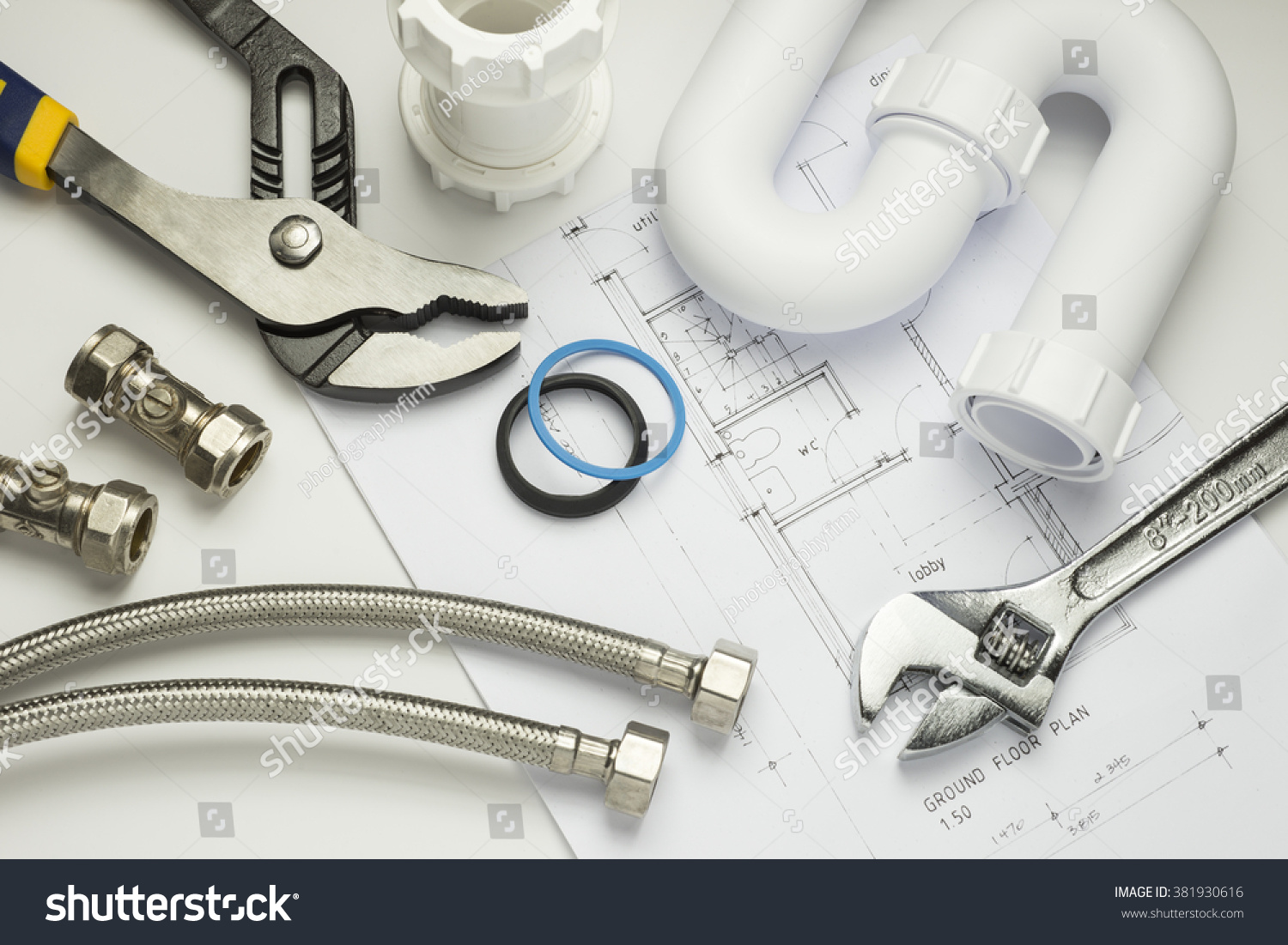 A selection of plumbing tools and fittings on house plans #381930616