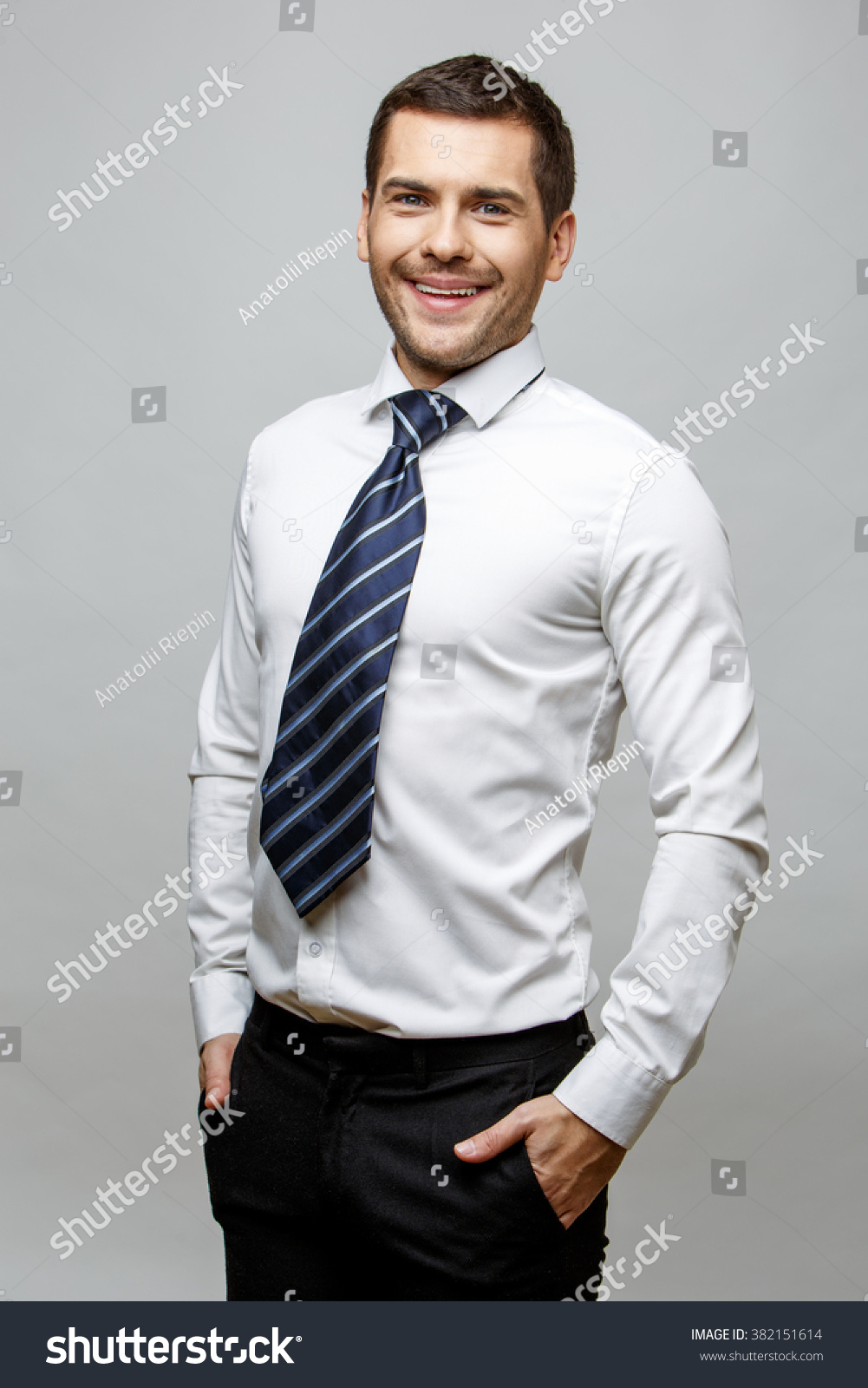 Handsome stylish businessman on grey background #382151614