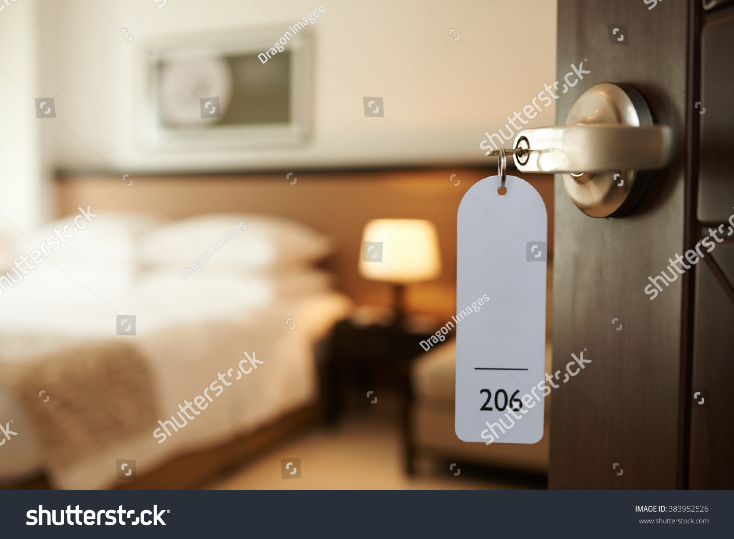 Opened door of hotel room with key in the lock #383952526