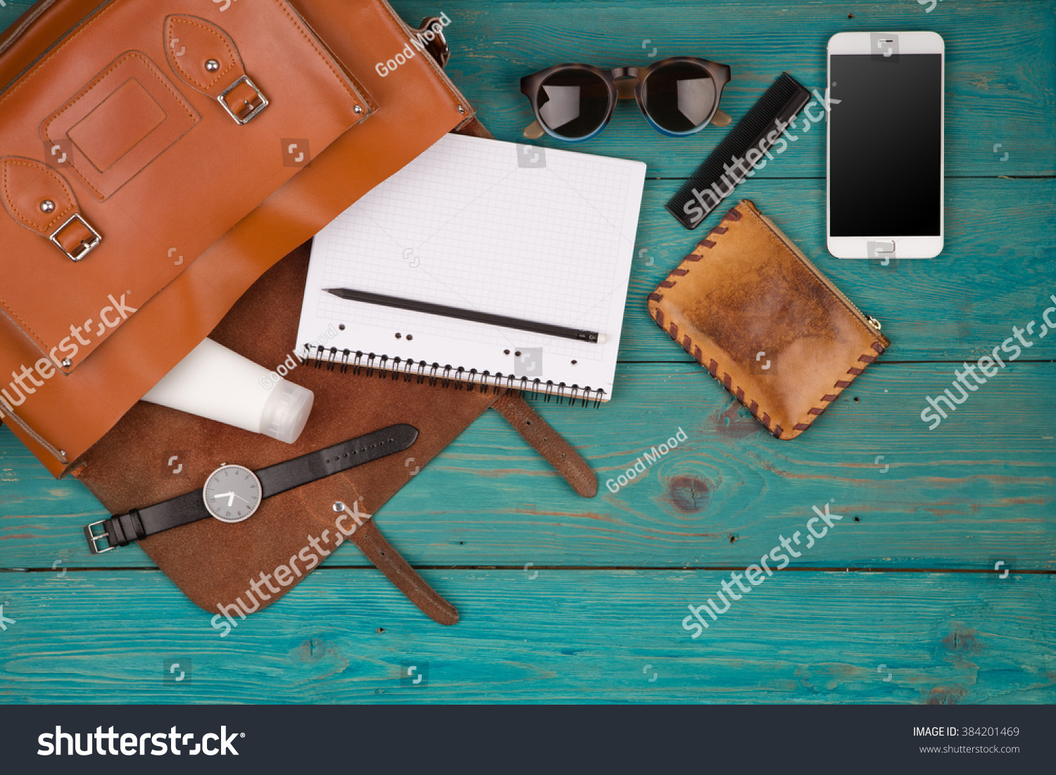 Travel concept - women set with bag with phone, notepad, purse, watch, glasses on blue wooden background. Top view #384201469