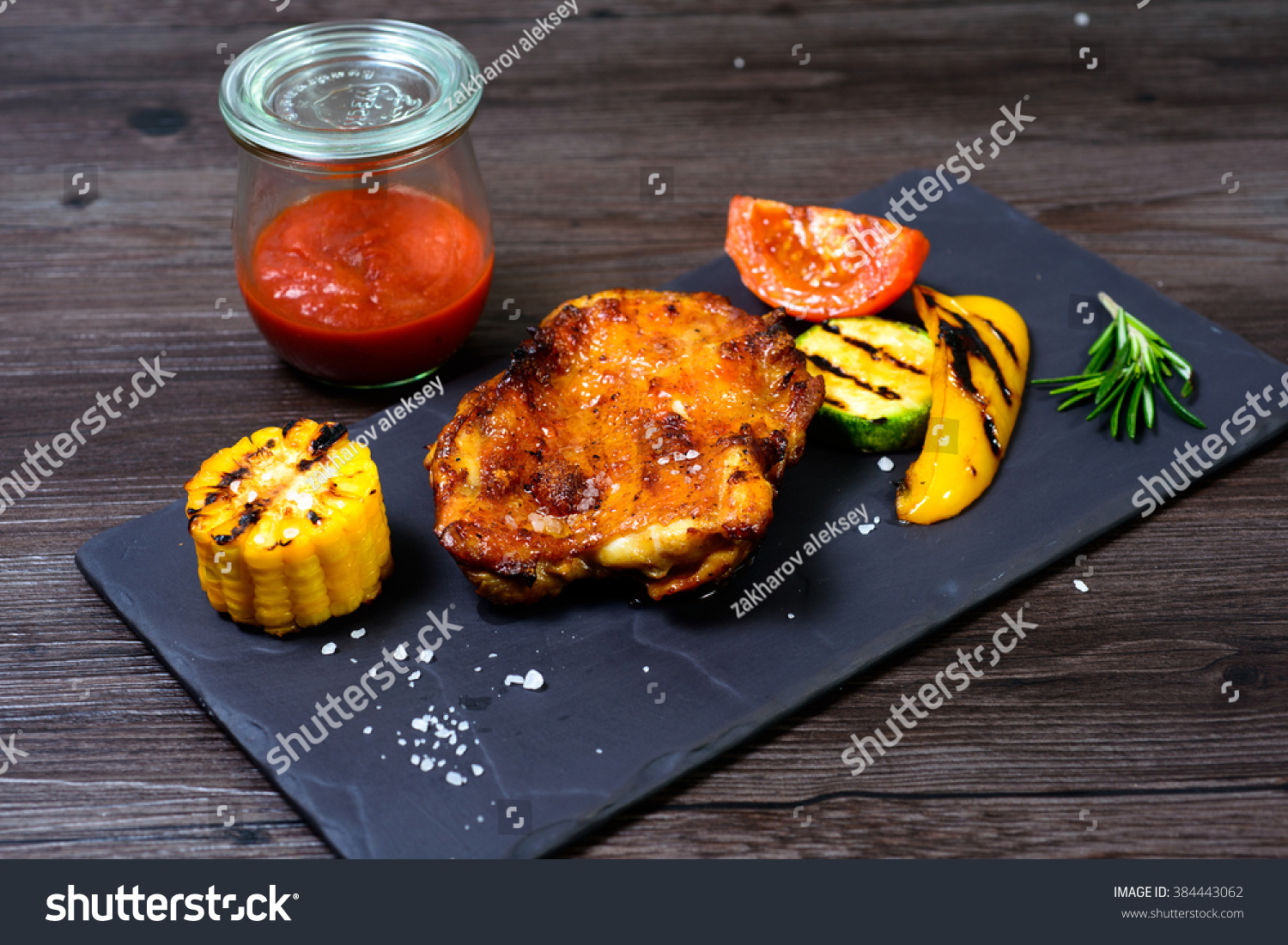 juicy grilled chicken with vegetables on a basalt slab #384443062