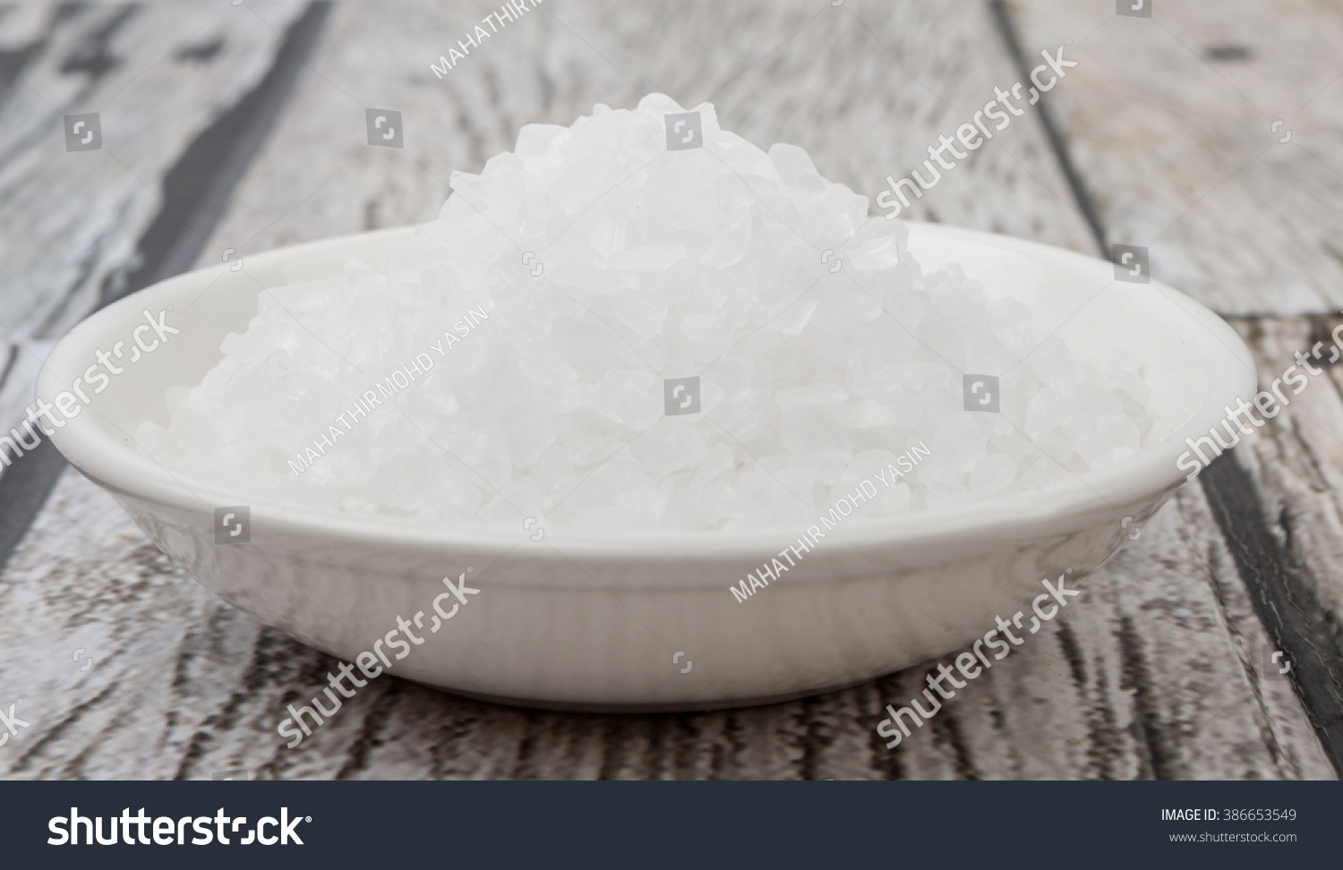 Sea salt in wooden bowl over wooden background #386653549