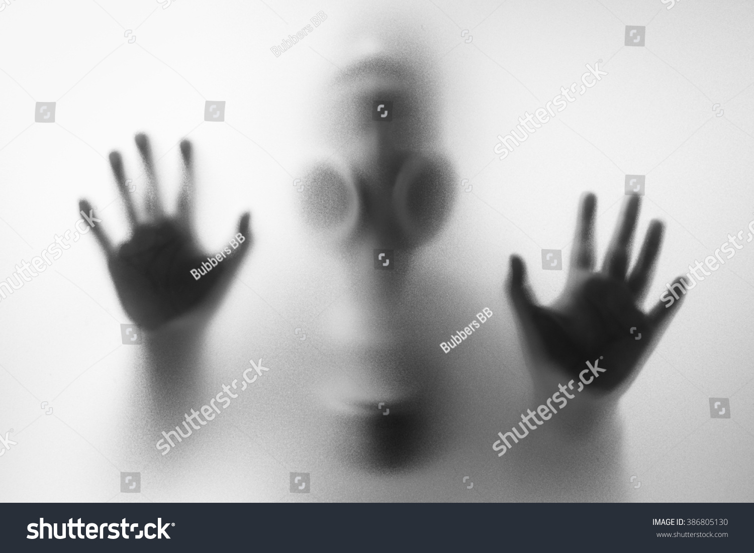 Woman wearing a gas mask behind the frosted glass #386805130