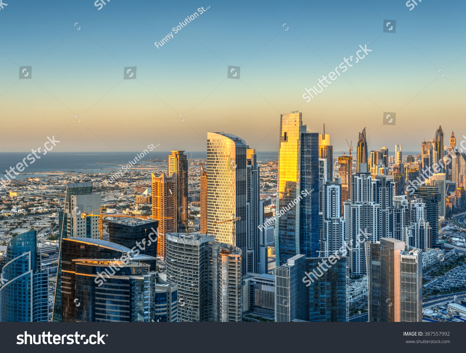 Beautiful skyline with modern architecture at sunset. Aerial view of Dubai business bay towers. #387557992