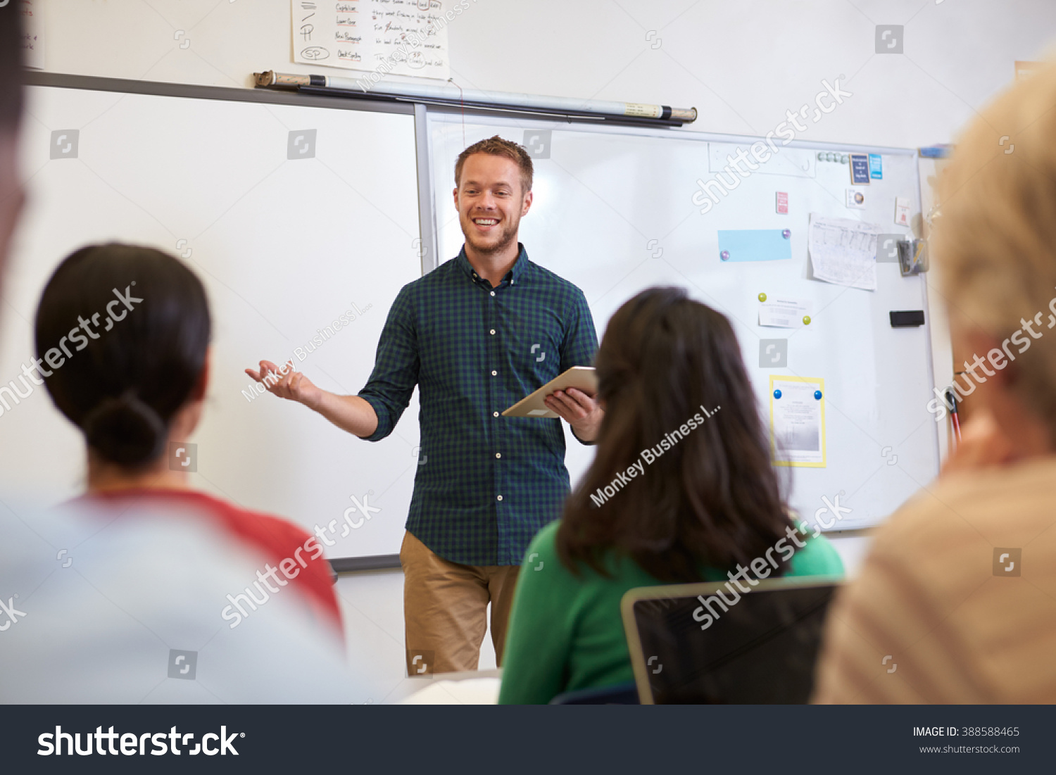 Male teacher listening to students at adult education class #388588465