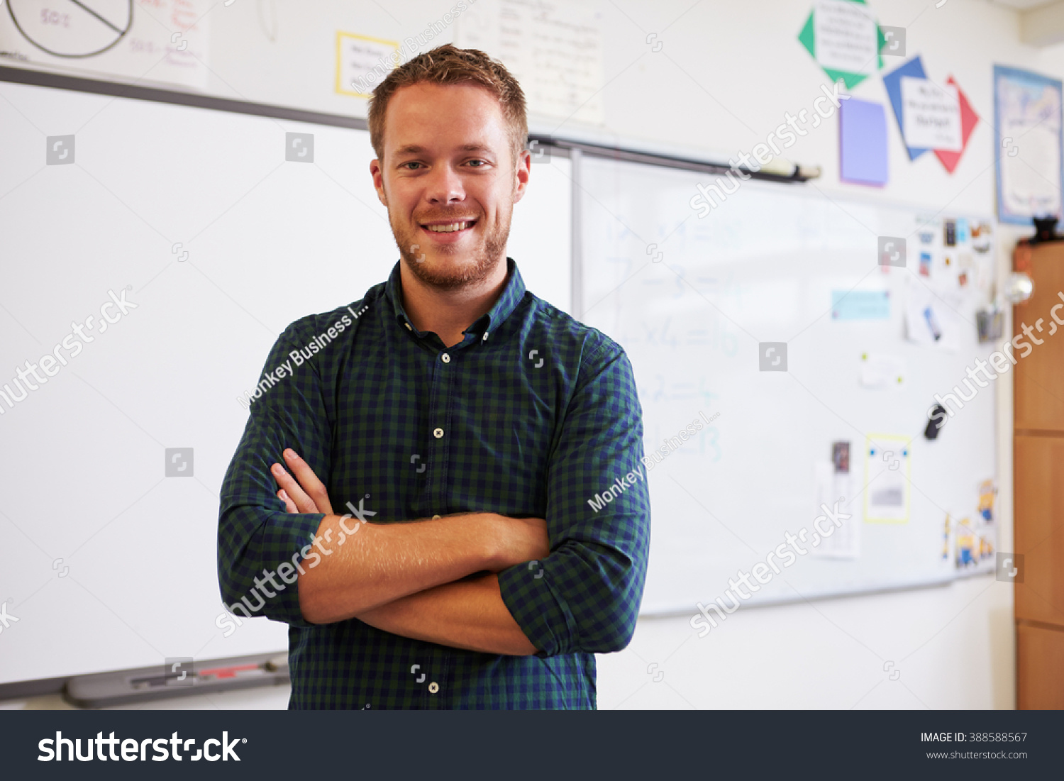 Portrait of confident Caucasian male teacher in classroom #388588567