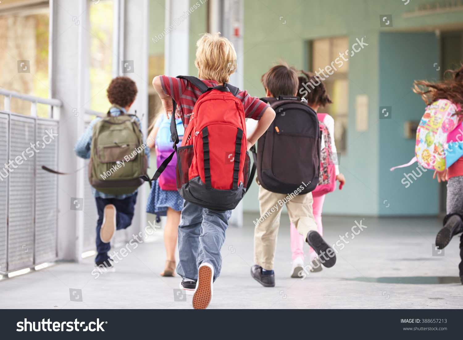 Group of elementary school kids running at school, back view #388657213