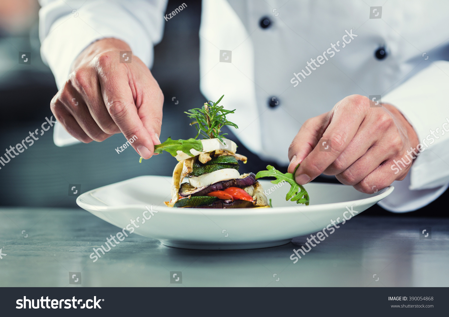 Chef in Restaurant garnishing vegetable dish, crop on hands, filtered image #390054868