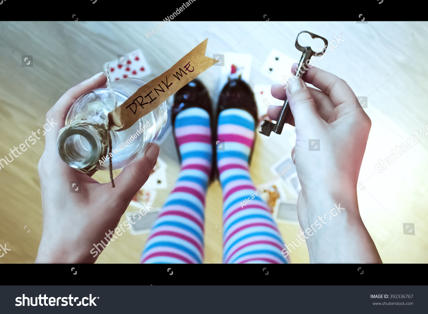 Alice in wonderland. Background. Key and potion in hands against a floor #392336767