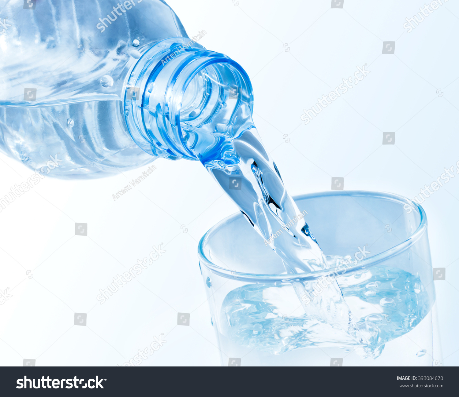 Pouring clean water from plastic bottle into a glass #393084670