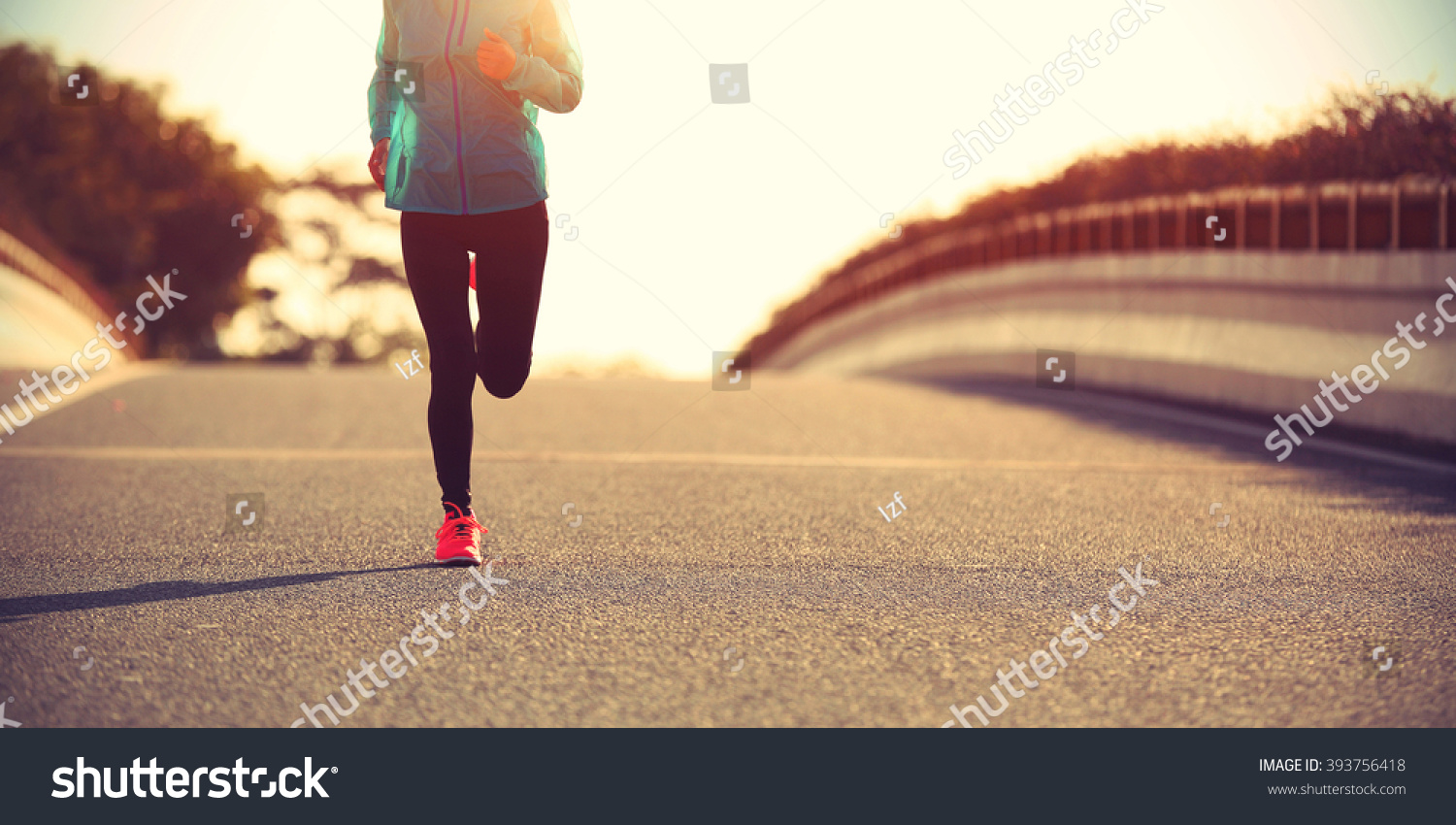 young fitness woman runner running on sunrise road #393756418