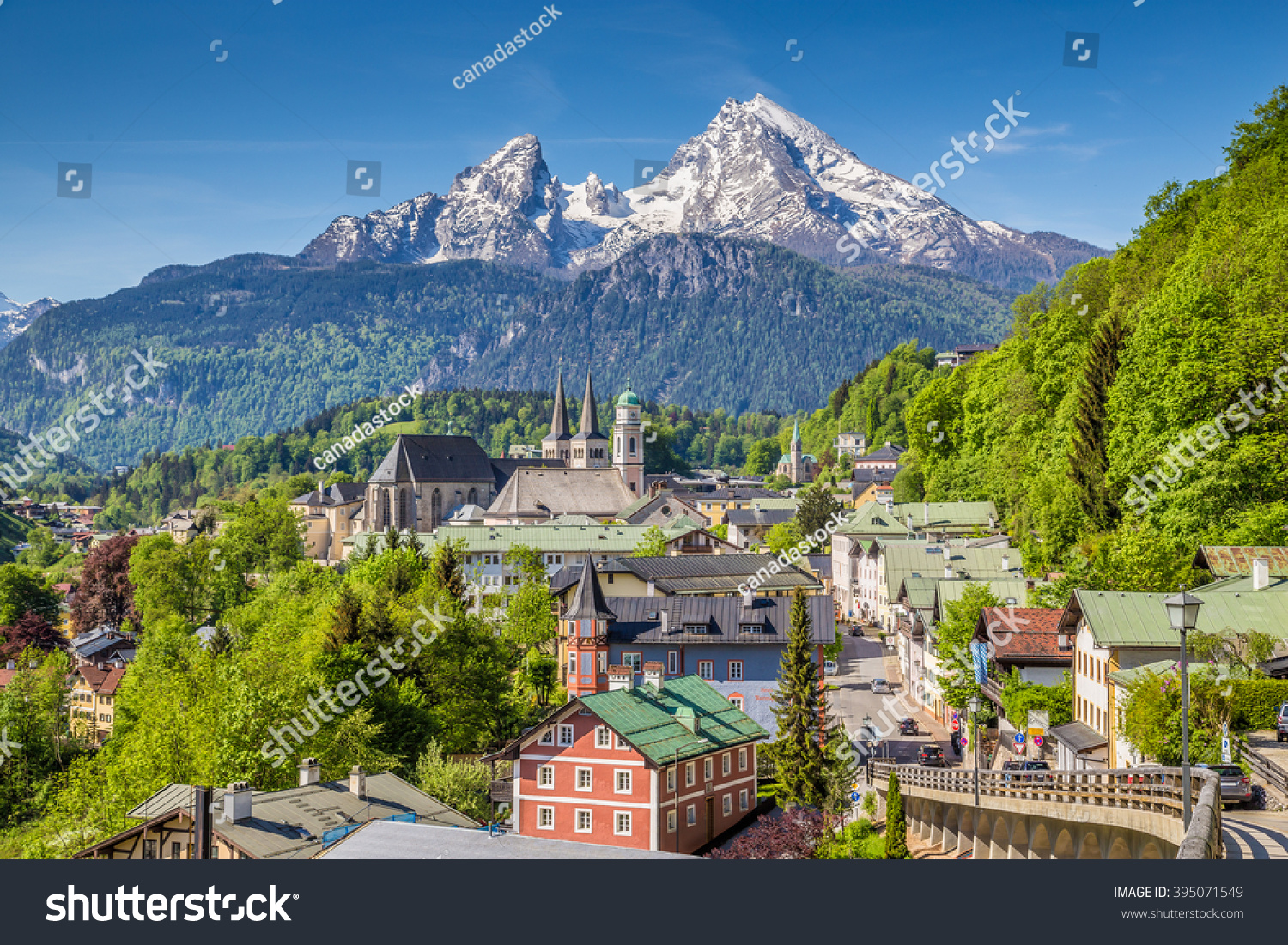 Historic town of Berchtesgaden with famous Watzmann mountain in the background on a sunny day with blue sky and clouds in springtime, Nationalpark Berchtesgadener Land, Upper Bavaria, Germany #395071549