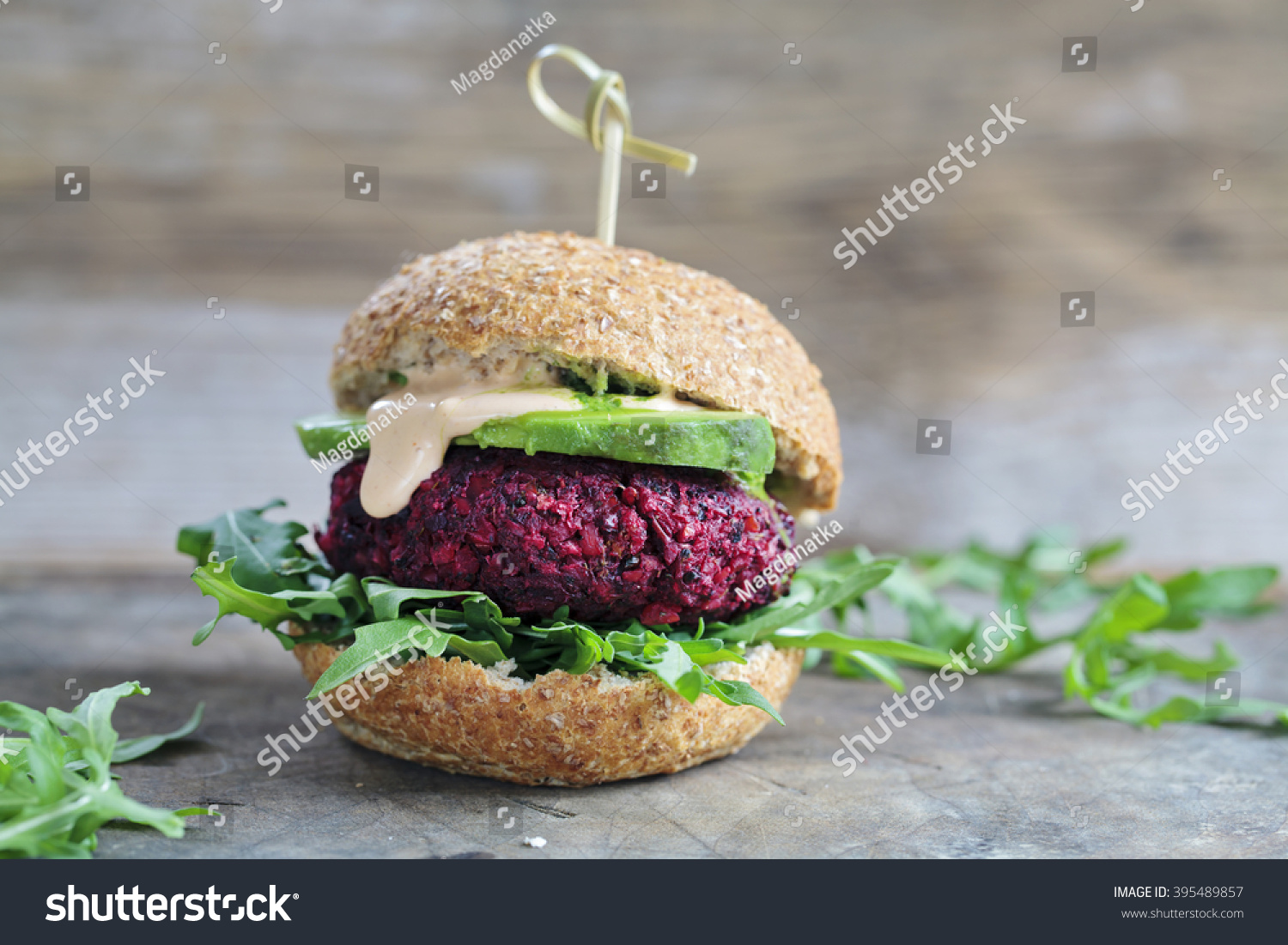 Vegetarian burger made of beetroot, broccoli and chickpeas with avocado and arugula #395489857