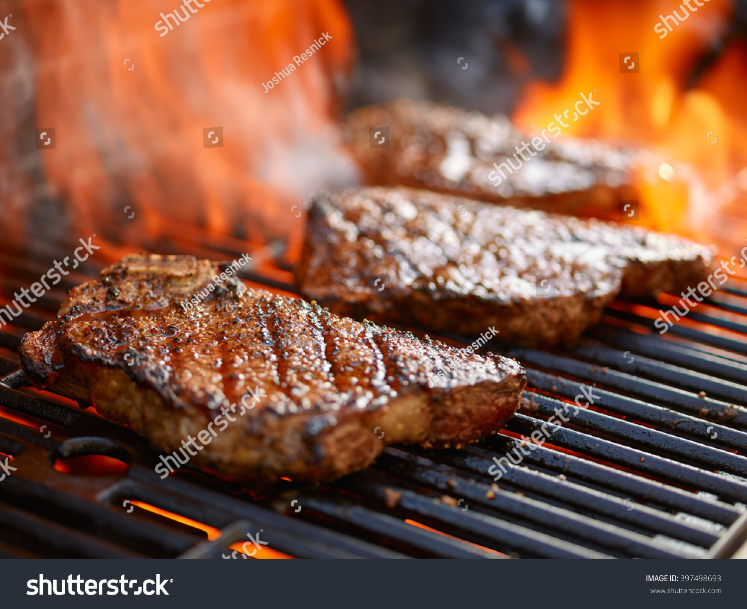 grilling steaks on flaming grill and shot with selective focus #397498693