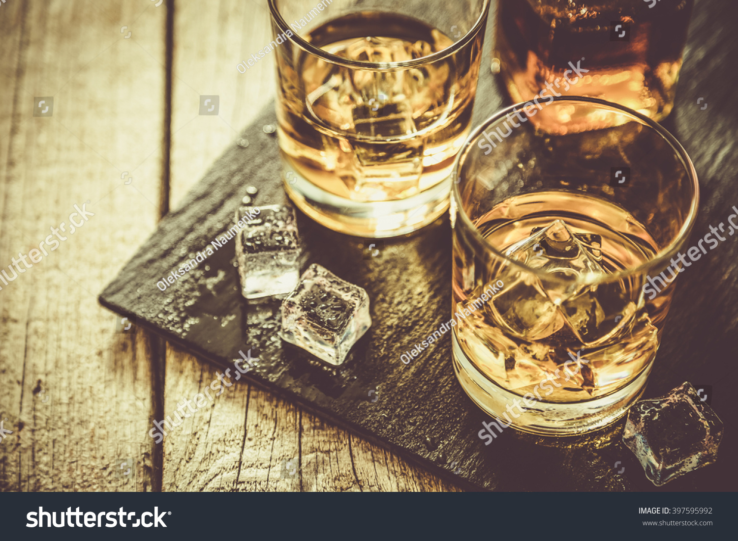 Whiskey with ice in glasses, rustic wood background, copy space #397595992