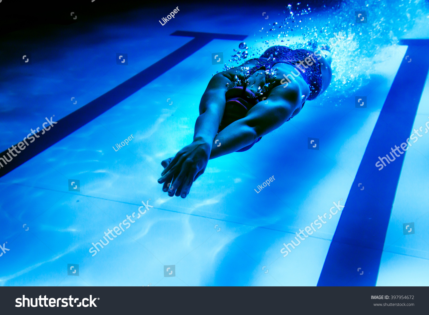 Female swimmer underwater/ Underwater shot of a swimmer diving after the jump in the swimming pool.  #397954672