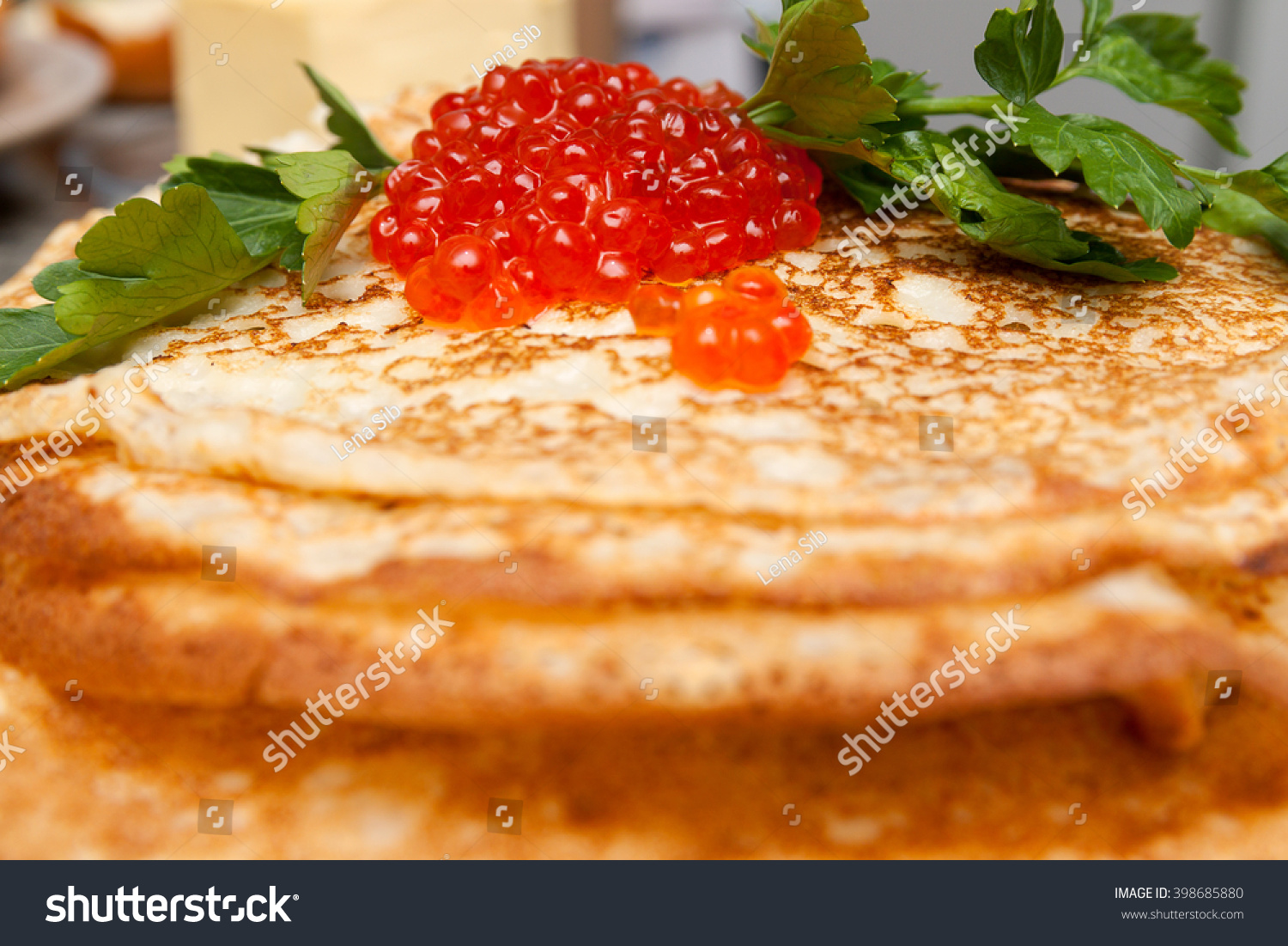 delicious pancakes with red caviar and parsley on a plate #398685880