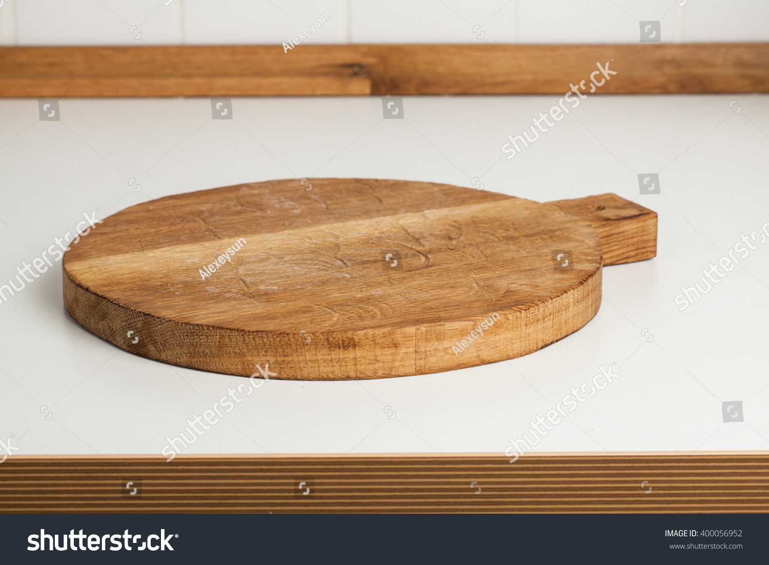 Empty round cutting board on a white kitchen top. #400056952