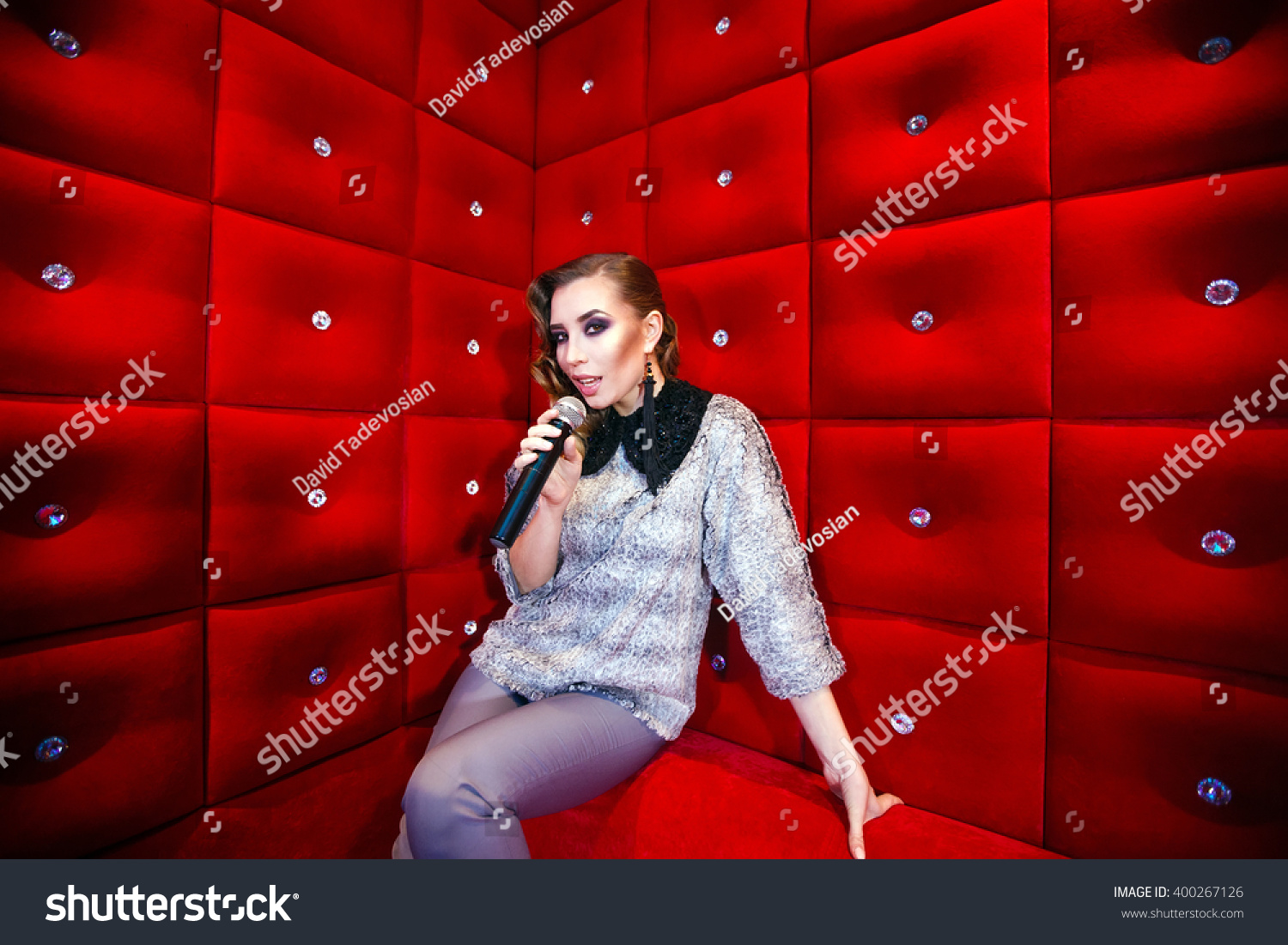 beautiful girl singing karaoke in a nightclub #400267126