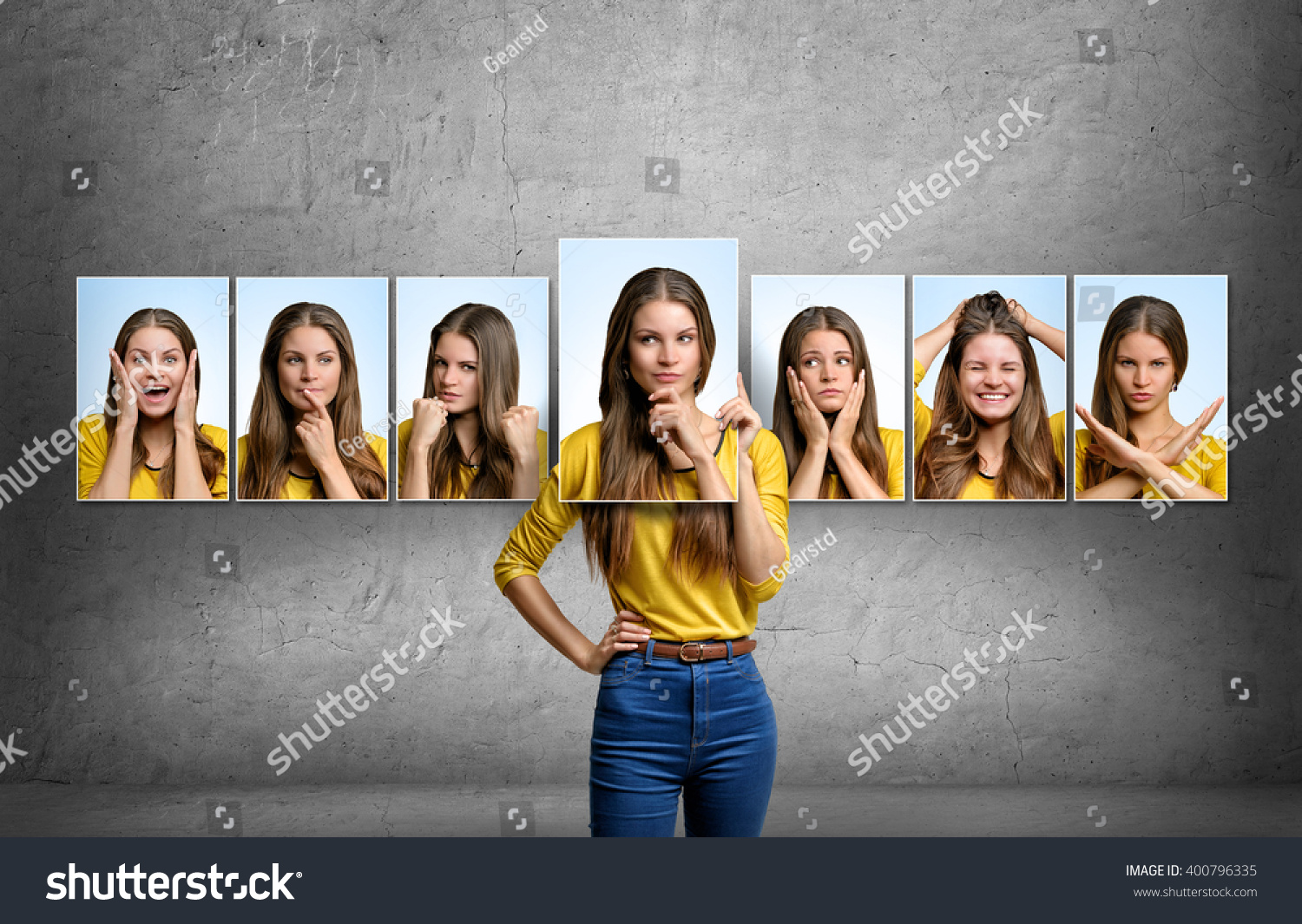 Girl holds and changes her face portraits with different emotions #400796335