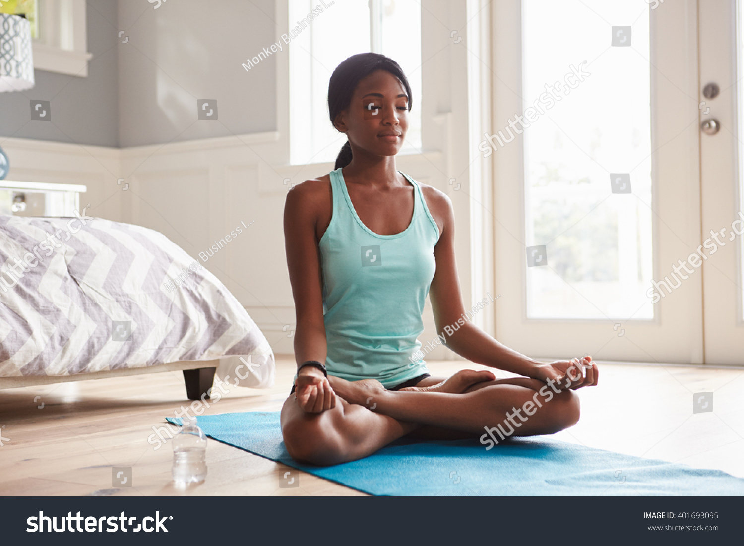 Young black woman doing yoga at home in the lotus position #401693095