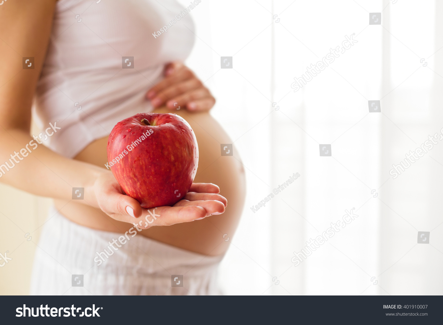 Pregnant woman holding apple in one hand  #401910007