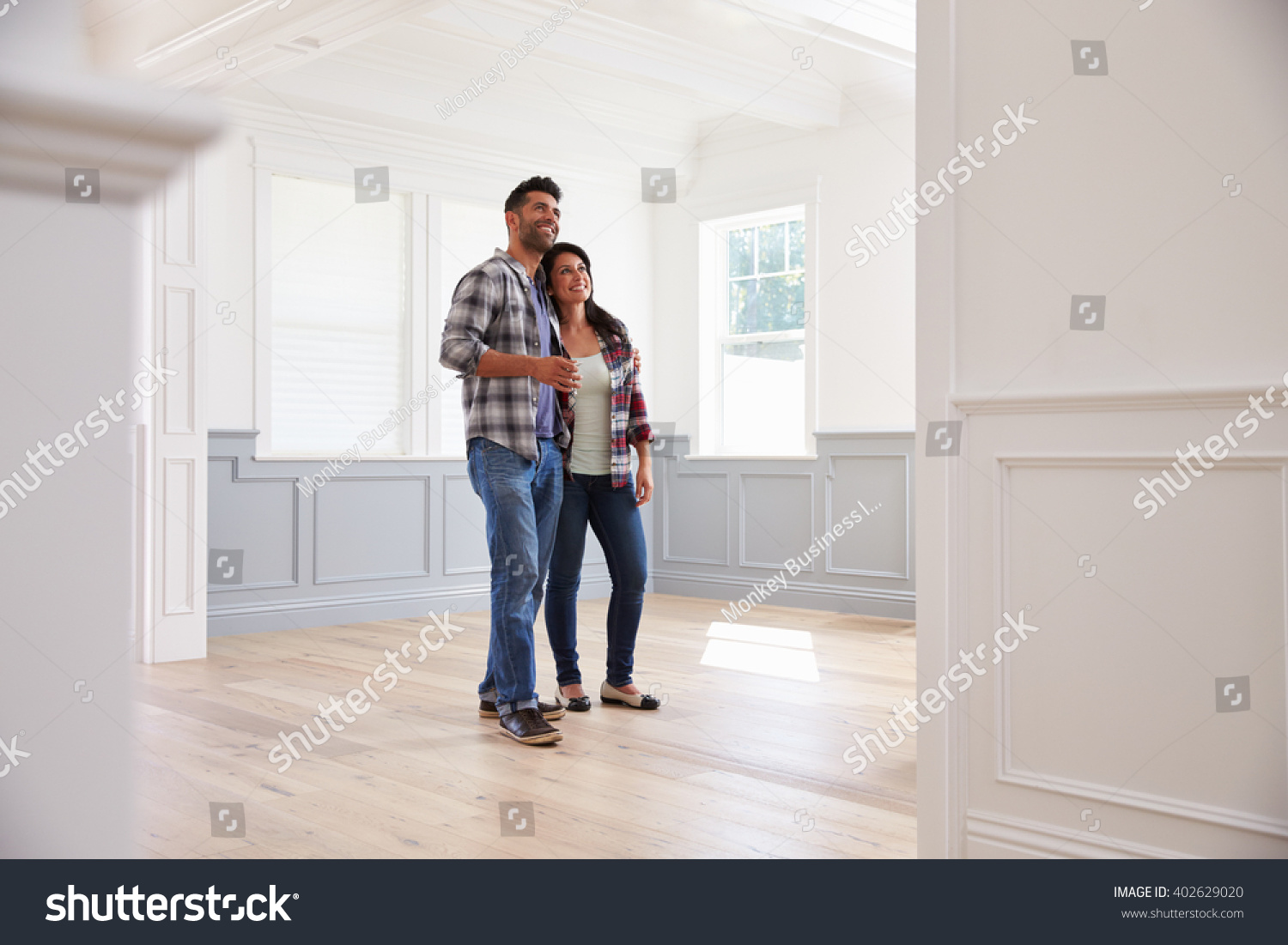 Hispanic Couple Viewing Potential New Home #402629020