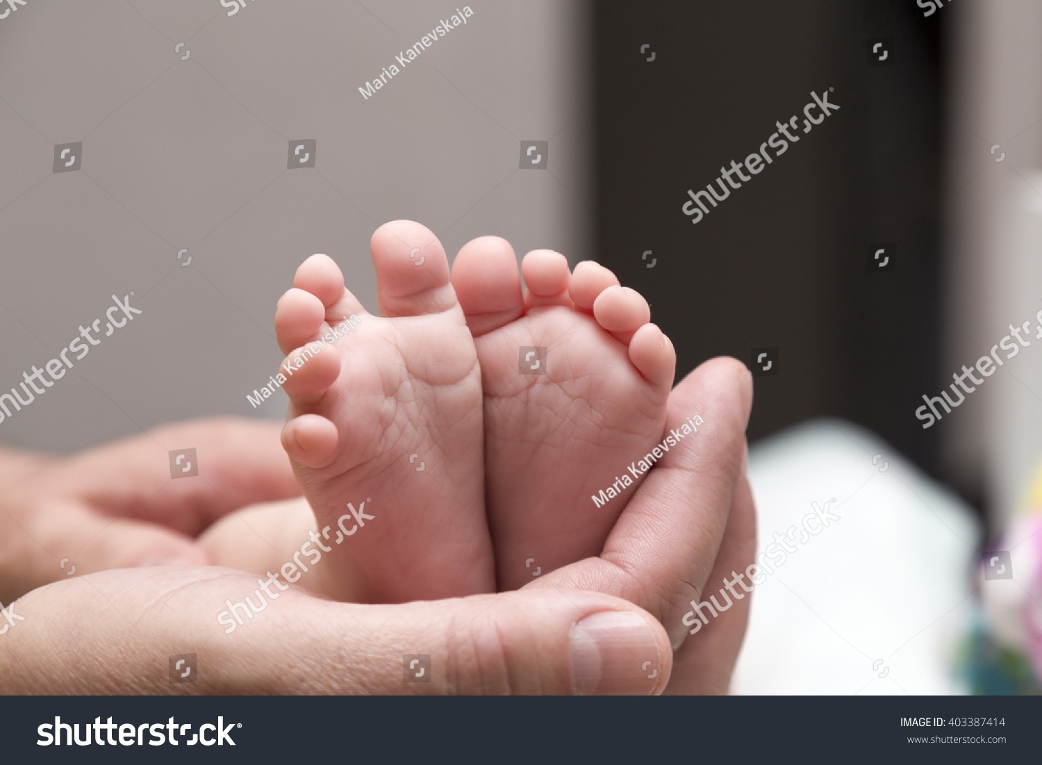 baby legs in adults hands #403387414