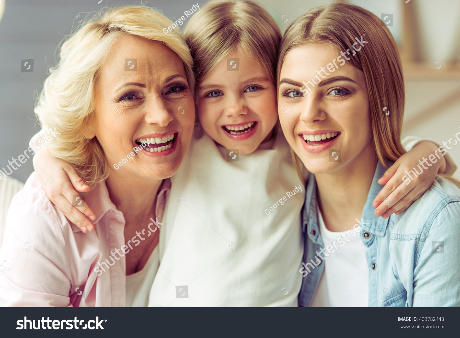 Portrait of three generations of happy beautiful women looking at camera, hugging and smiling #403782448
