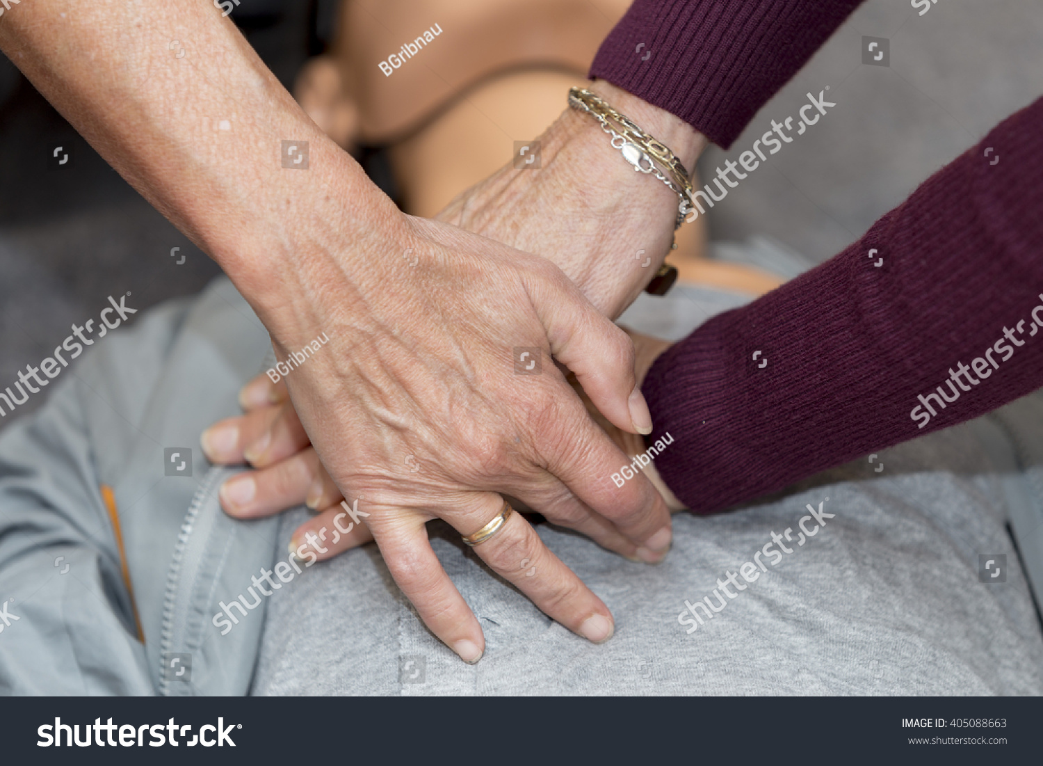 Hands of women are seen on a mannequin during an exercise of resuscitation #405088663