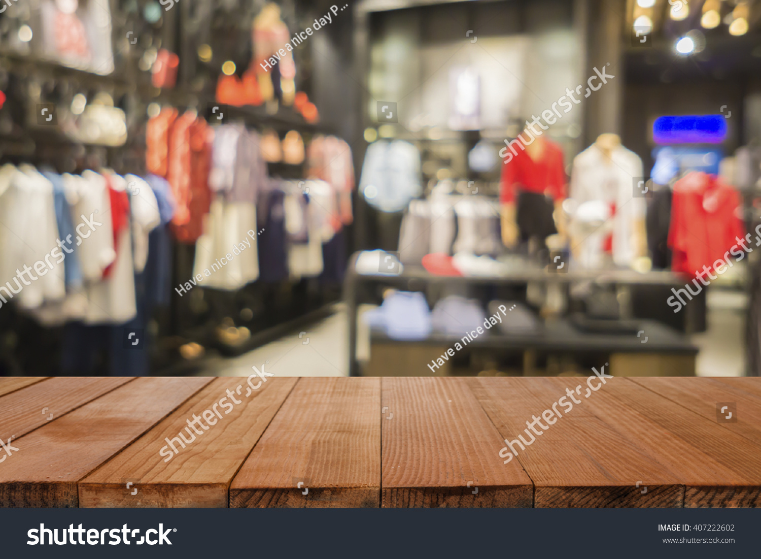 Empty brown wooden table and De focused/blurry background of Sports clothing store with bokeh image luxury and fashionable brand,can be used for montage or display your products #407222602