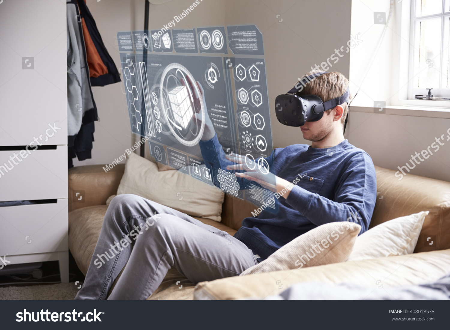 Man Sitting On Sofa At Home Wearing Virtual Reality Headset #408018538