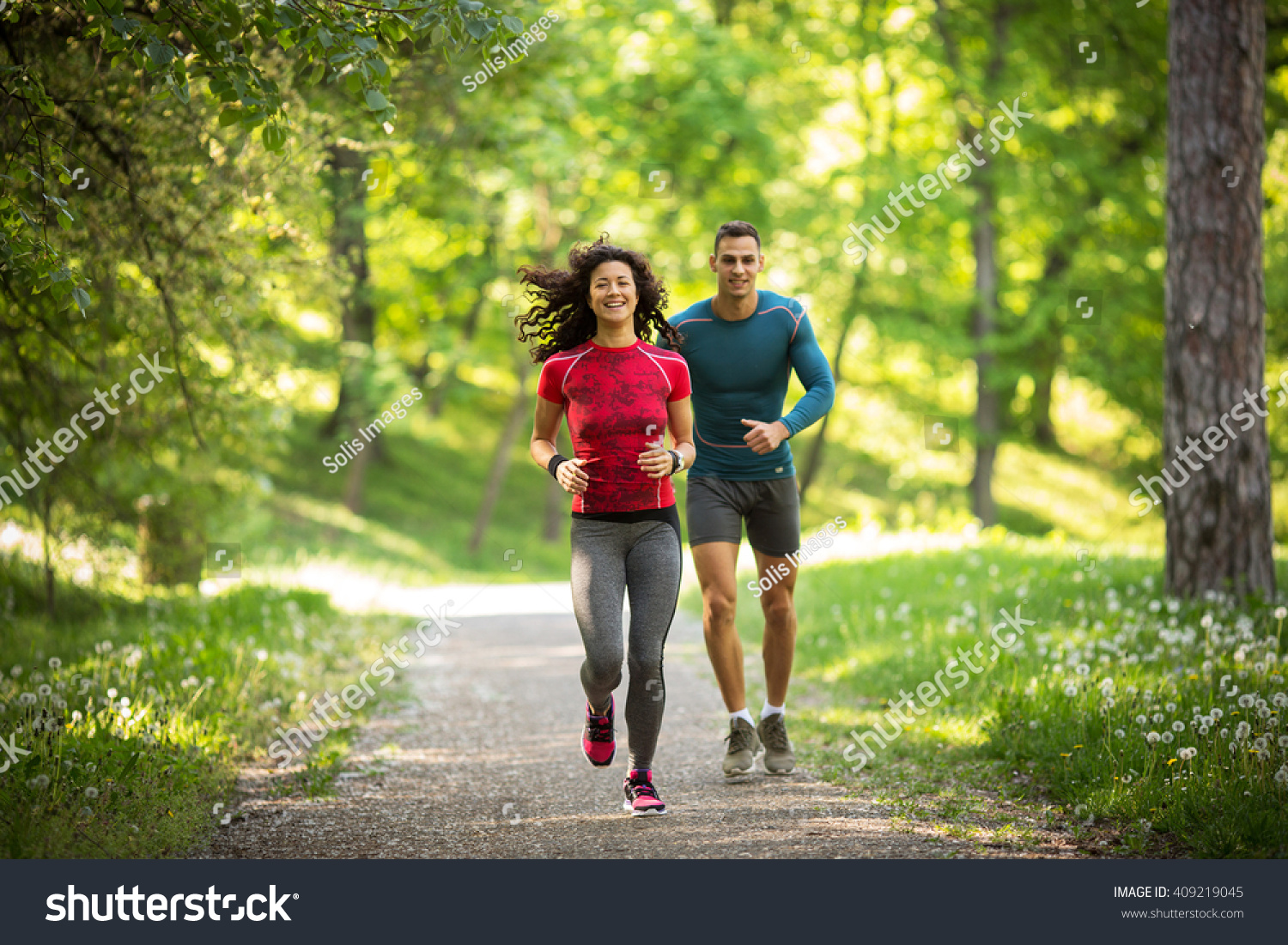 Young couple jogging at the woods.Green environment. #409219045