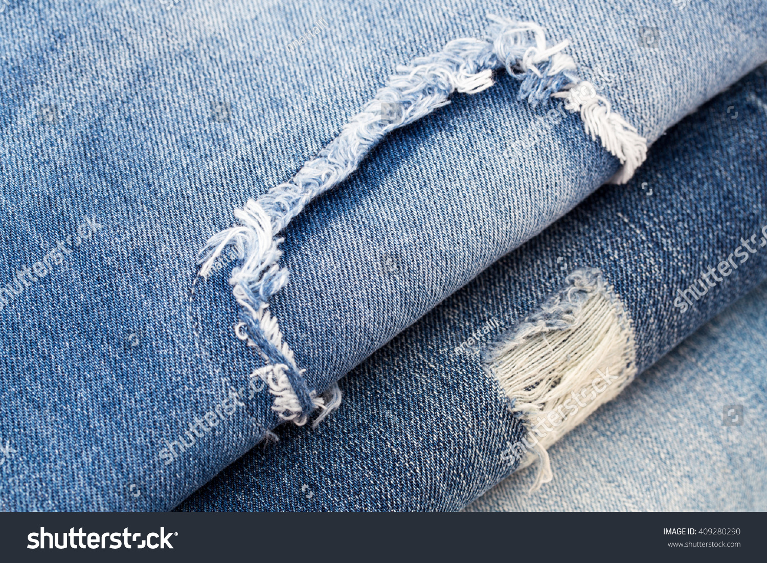 Destroyed torn ripped denim blue jeans with patch, close up, Flat Lay #409280290
