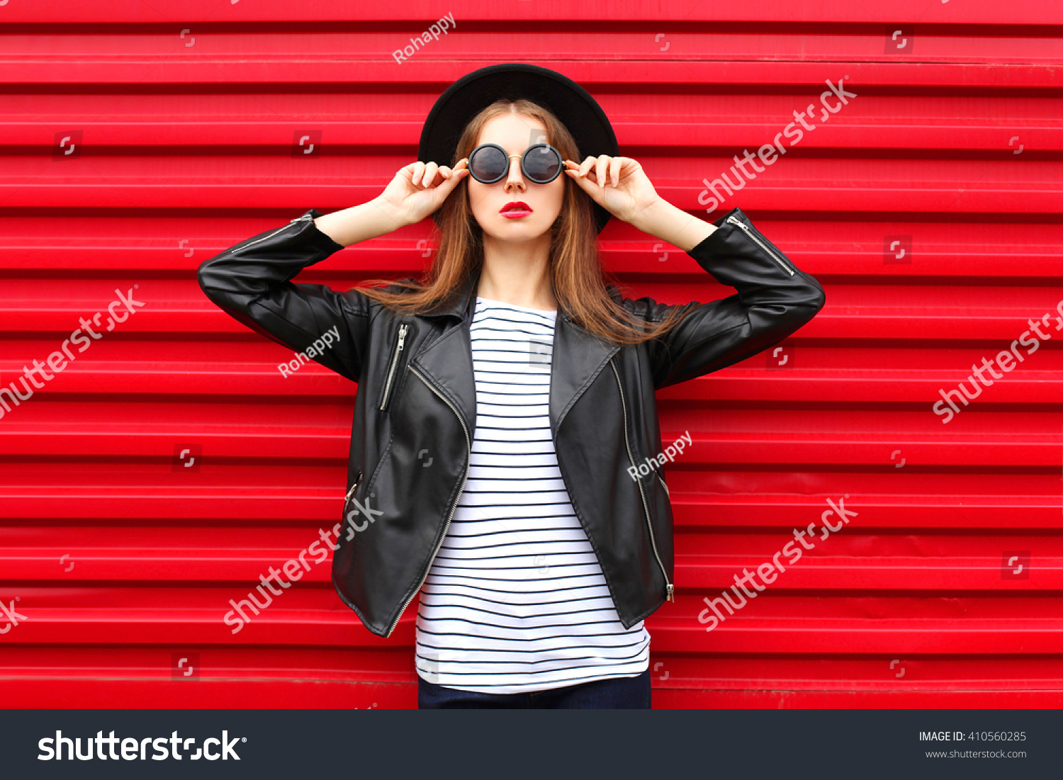 Fashion portrait woman in black rock style on red background #410560285