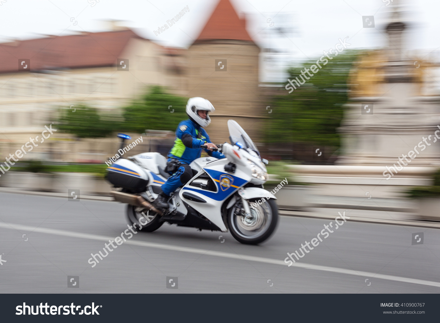 ZAGREB, CROATIA - APRIL 24, 2016: - International cycling race Tour of Croatia 2016. - Stage 6. Policeman on motorcycle passing by cathedral. #410900767