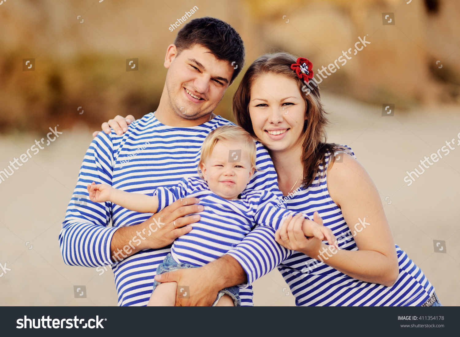 the loving careful parents on sand have a good time with the child #411354178