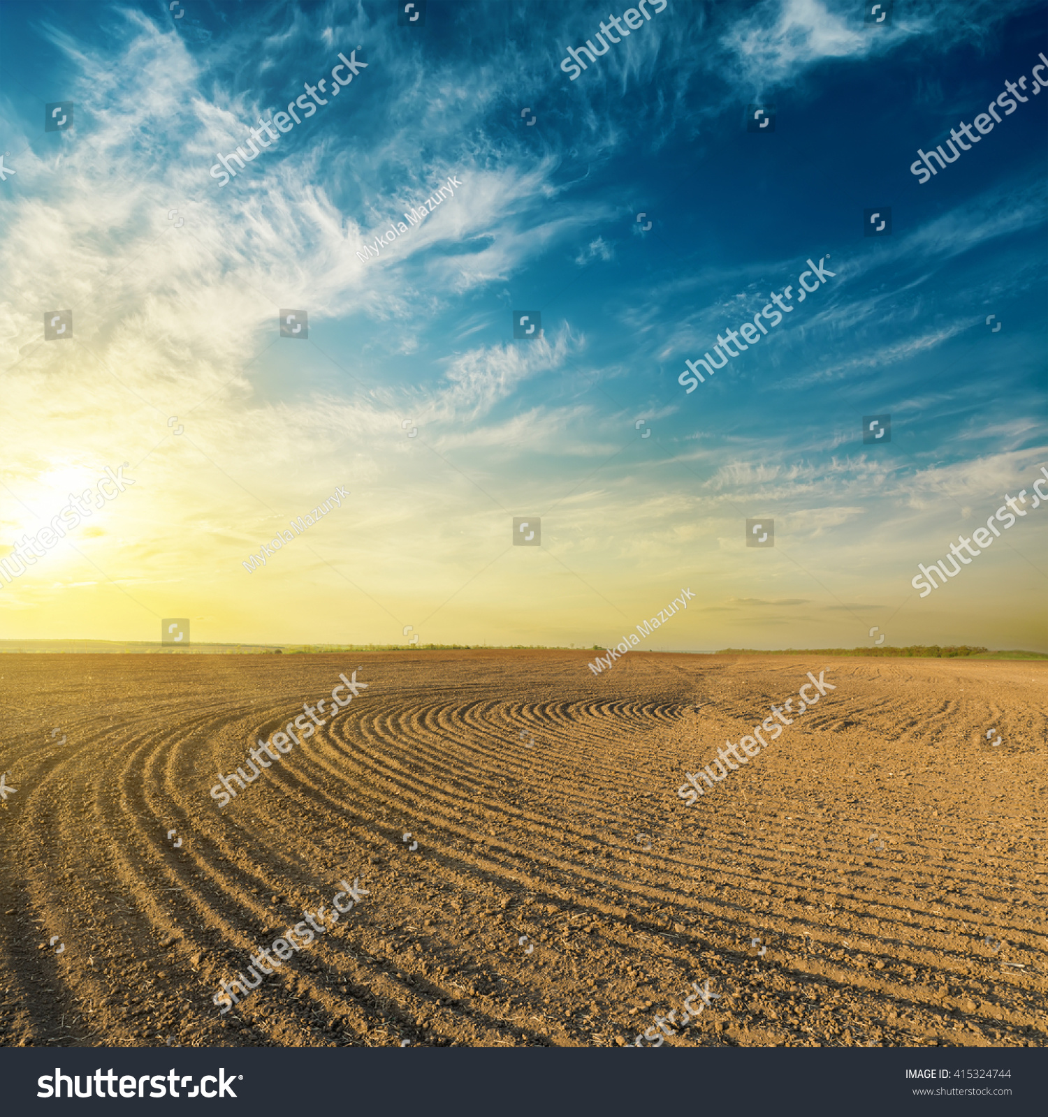 black plowed field in sunset #415324744