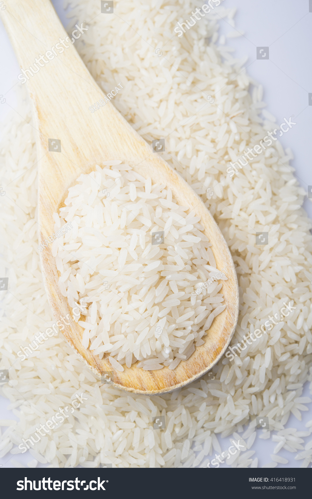 food background. brown rice in a wooden spoon. top view #416418931