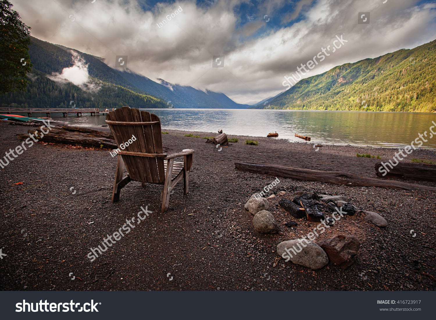 Empty wooden chair next to a burnt out camp fire beside Lake Crescent in Washington State. #416723917