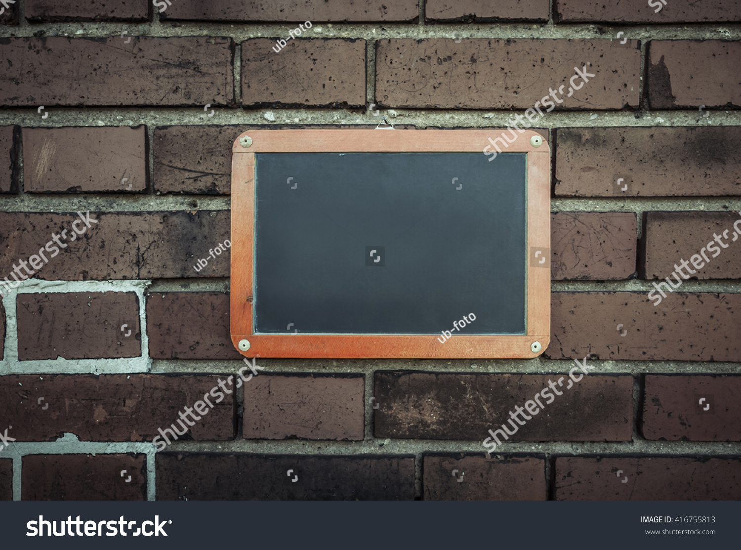 Empty blackboard on a brick wall with copy space. #416755813