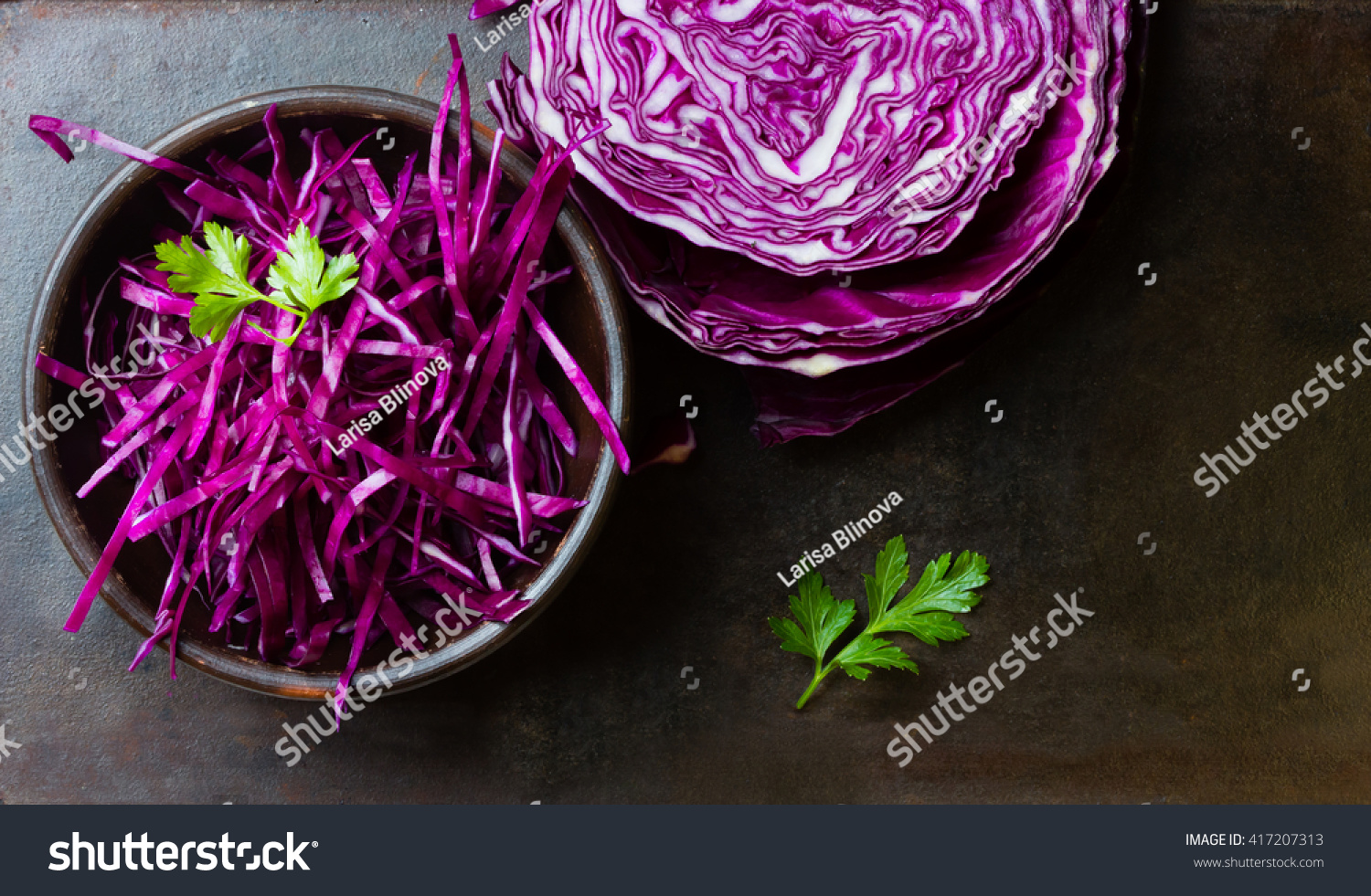 Shredded red cabbage in clay bowl on black background. Vegetarian healthy food. Top view #417207313