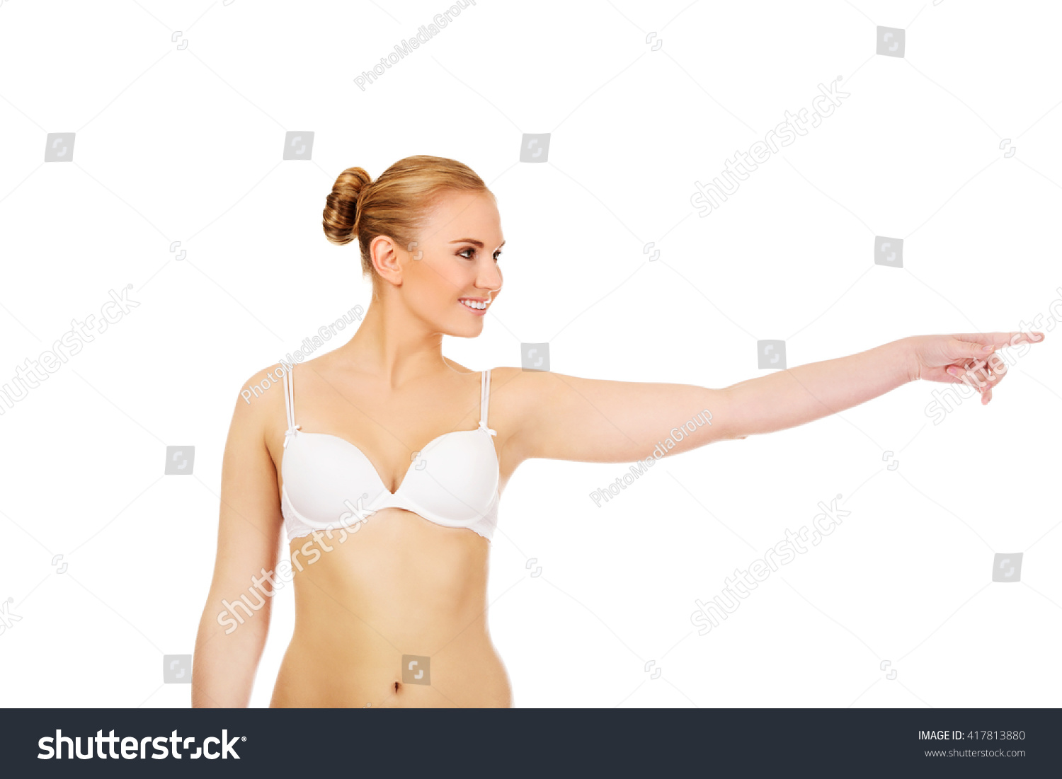 Young woman in white bra pointing for copyspace or something #417813880