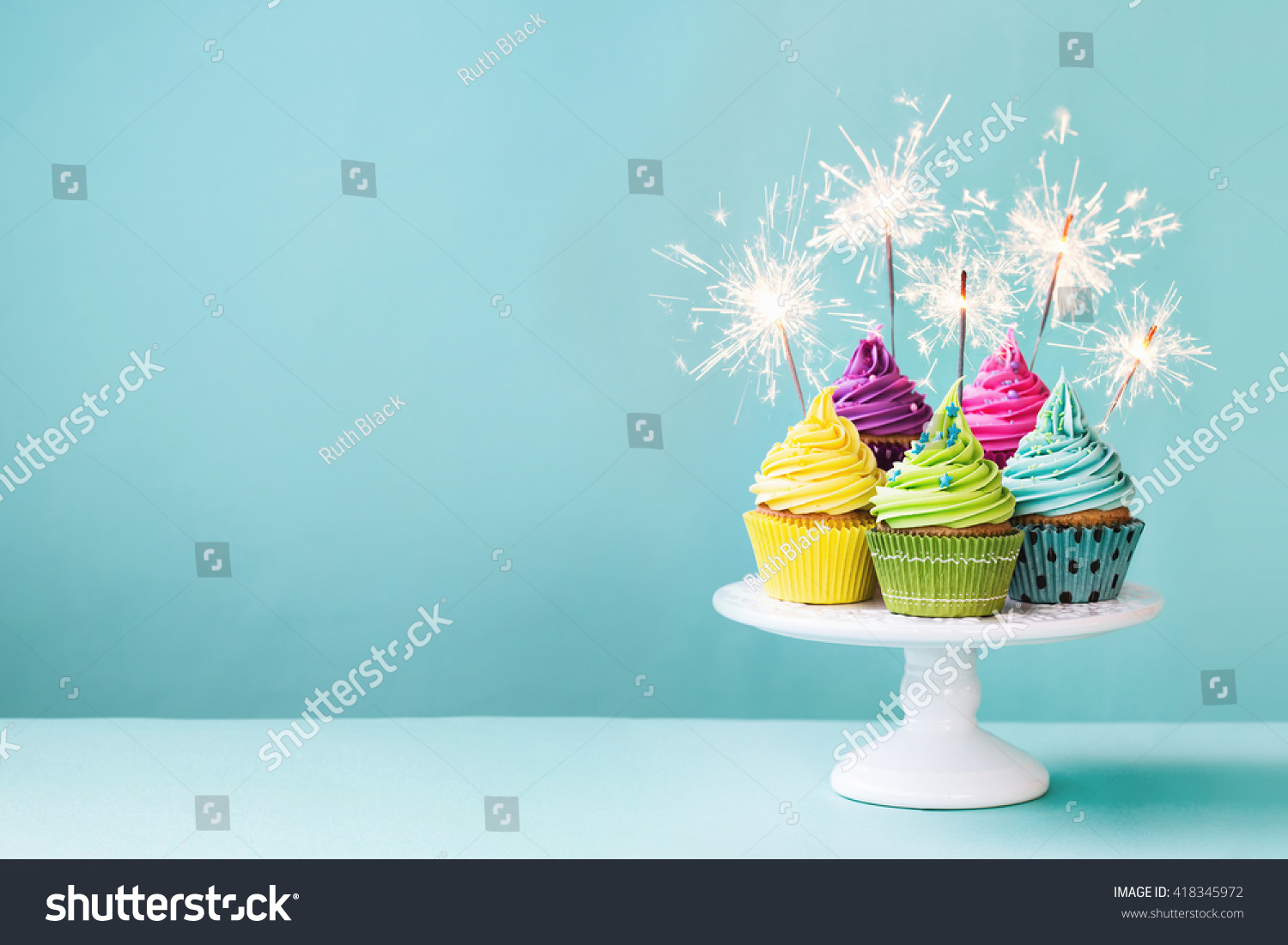 Cupcakes on a cake stand with sparklers #418345972