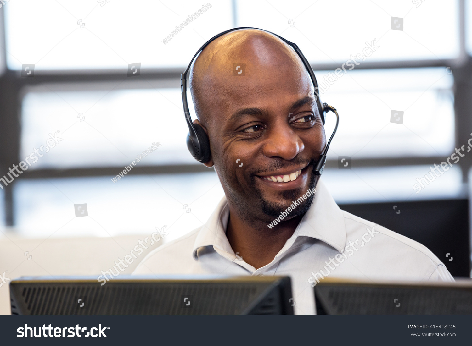 Man working on computer with headset in office #418418245