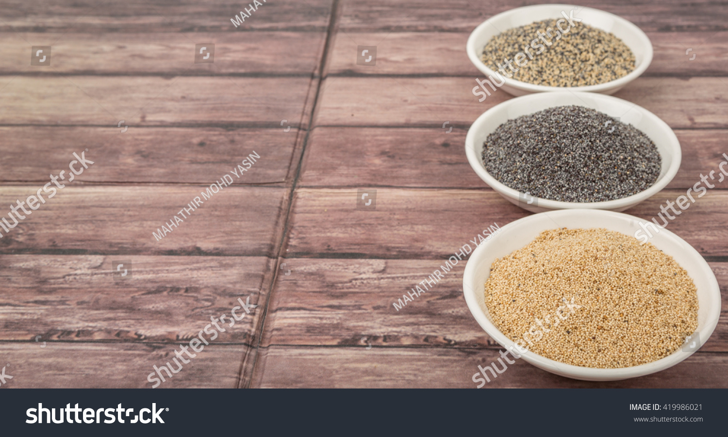 White poppy seed, black poppy seed and mix poppy seed in white bowls over wooden background #419986021